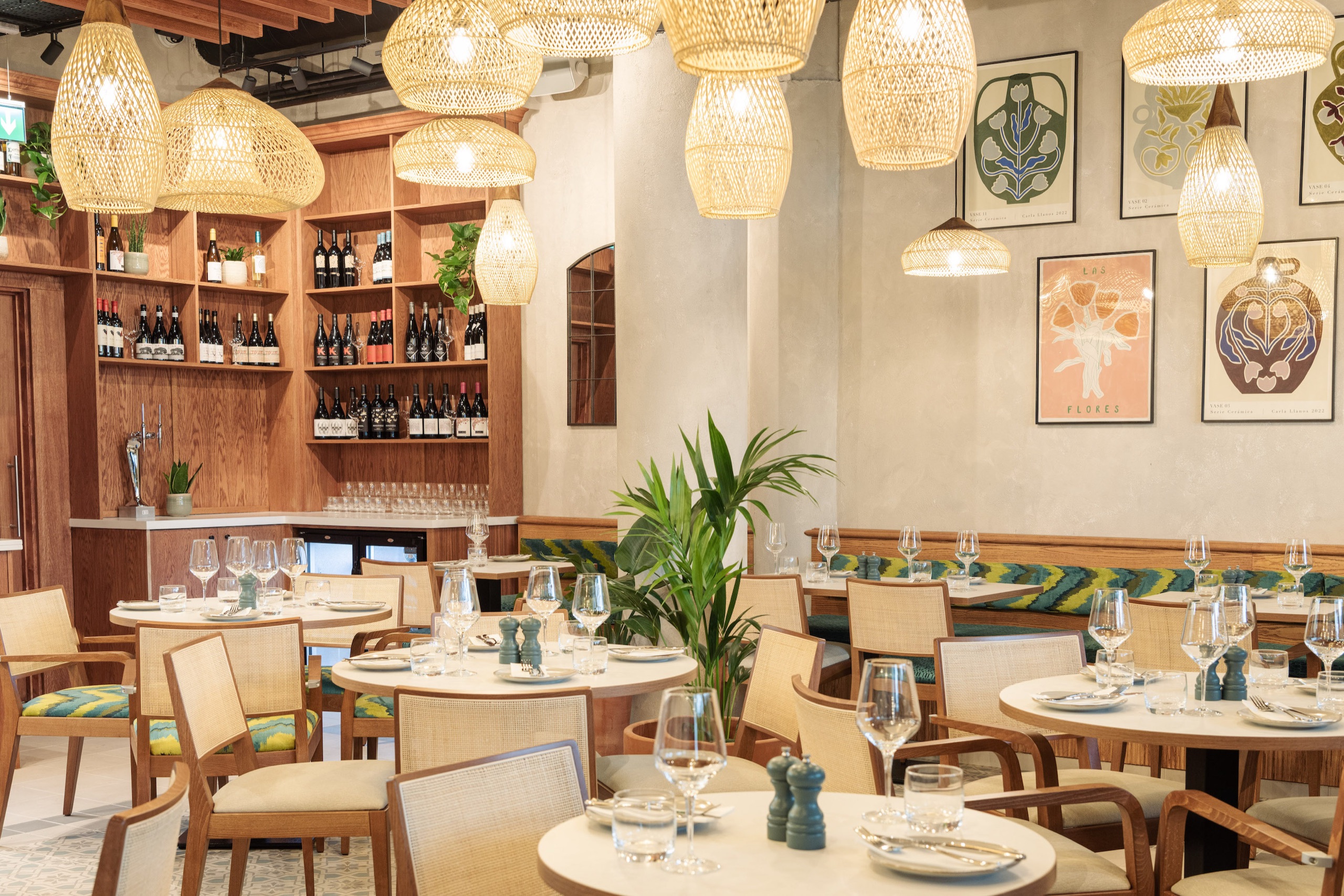 La Gamba's bright dining room — rattan lamps, wine wall and framed artwork (photo: Rebecca Dickson)